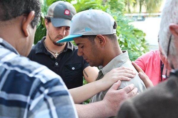 Group on short term mission trip in Brazil Praying for local man